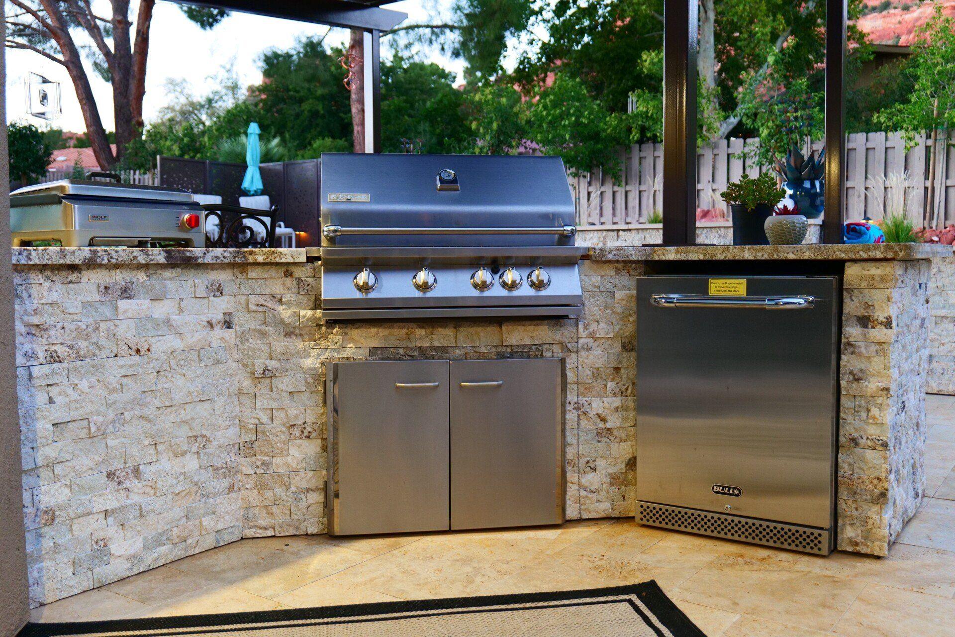 Outdoor kitchen with built-in grill under a ramada
