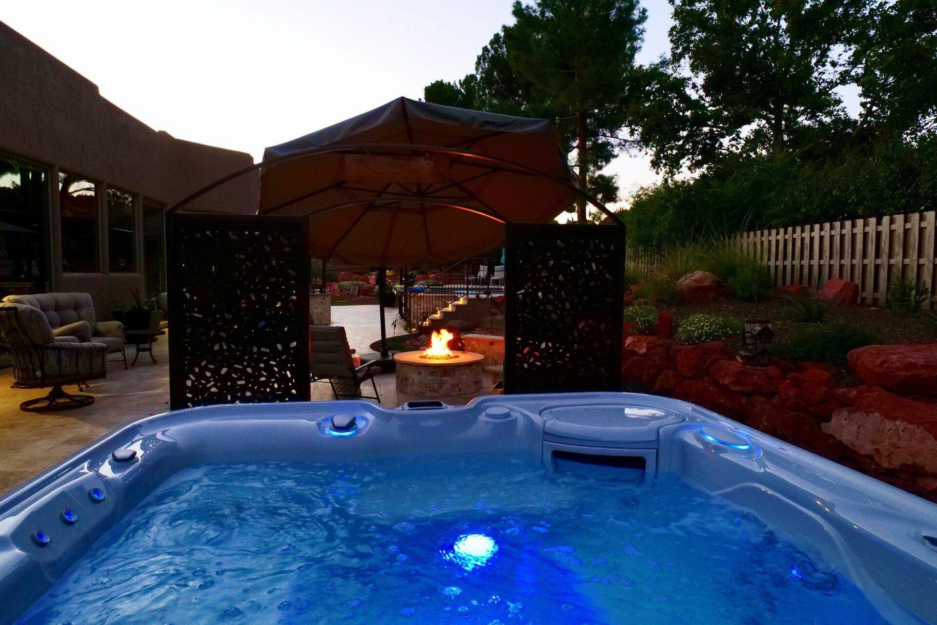 Spa lit at night beside a fire feature
